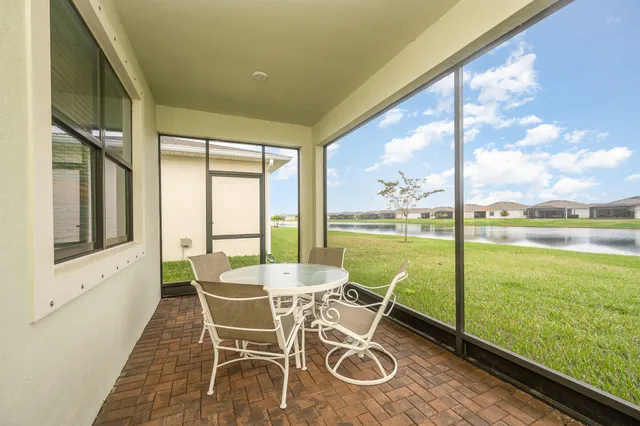 a dining room with furniture and floor to ceiling windows