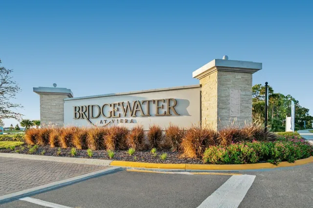 a front view of a house with a yard and potted plants