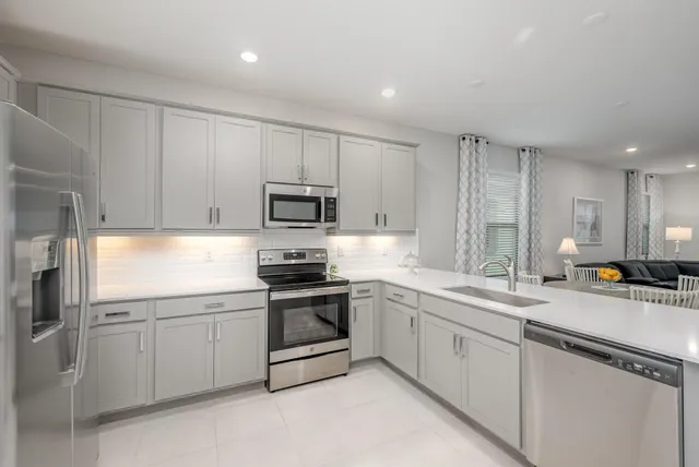 a kitchen with appliances a sink and cabinets