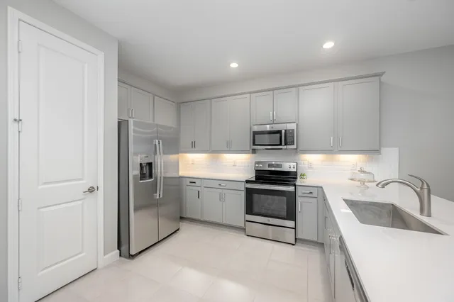 a kitchen with white cabinets and stainless steel appliances