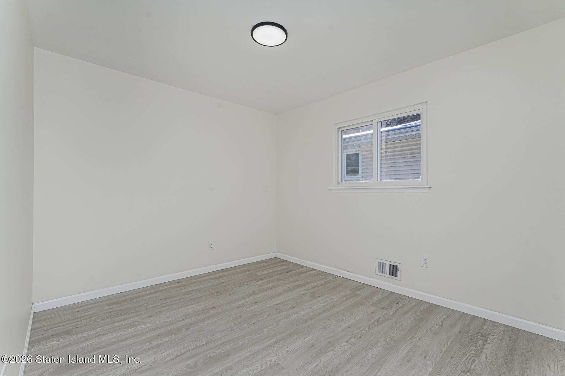 39 Commerce Street Staten Island, NY 10314 - Photo 31 of 49 an empty room with wooden floor and windows