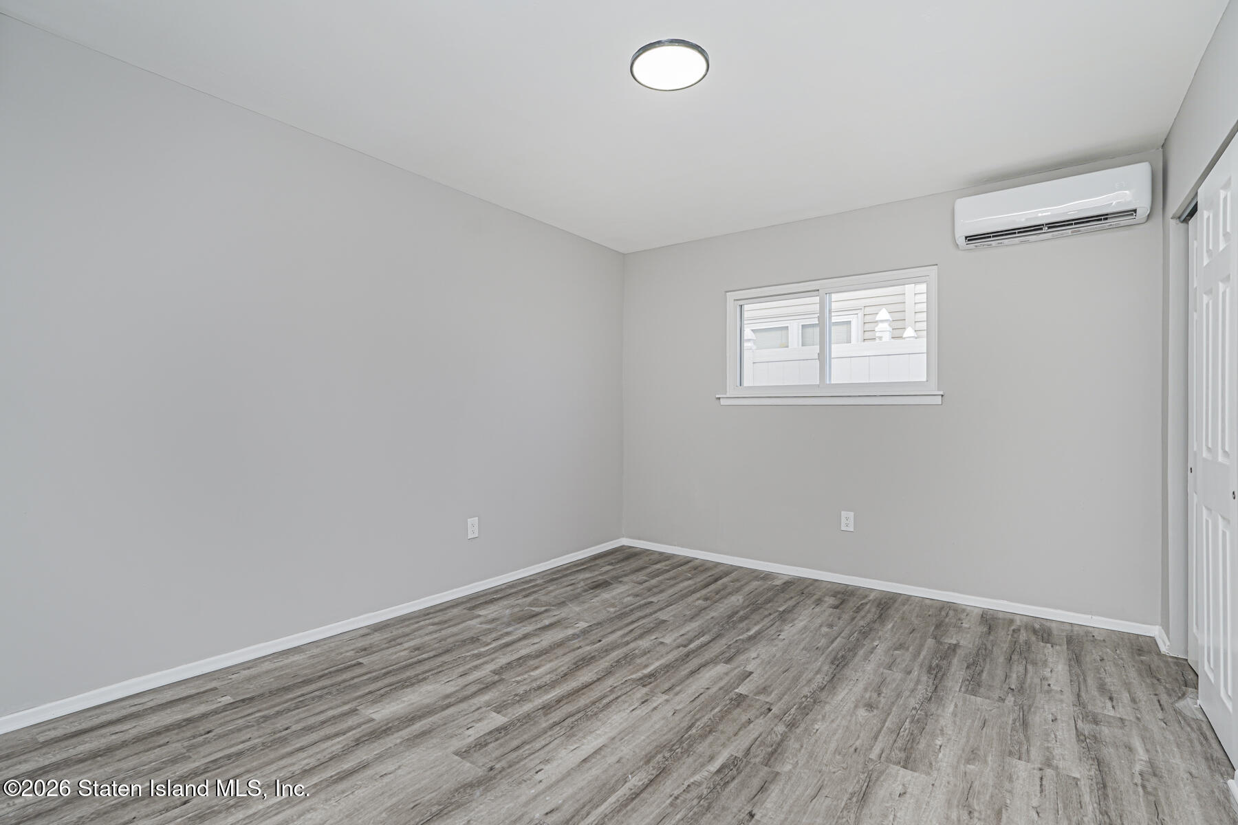 39 Commerce Street Staten Island, NY 10314 - Photo 43 of 49 an empty room with wooden floor and windows