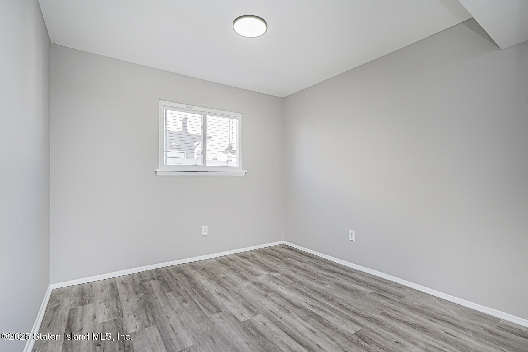39 Commerce Street Staten Island, NY 10314 - Photo 45 of 49 an empty room with wooden floor and windows