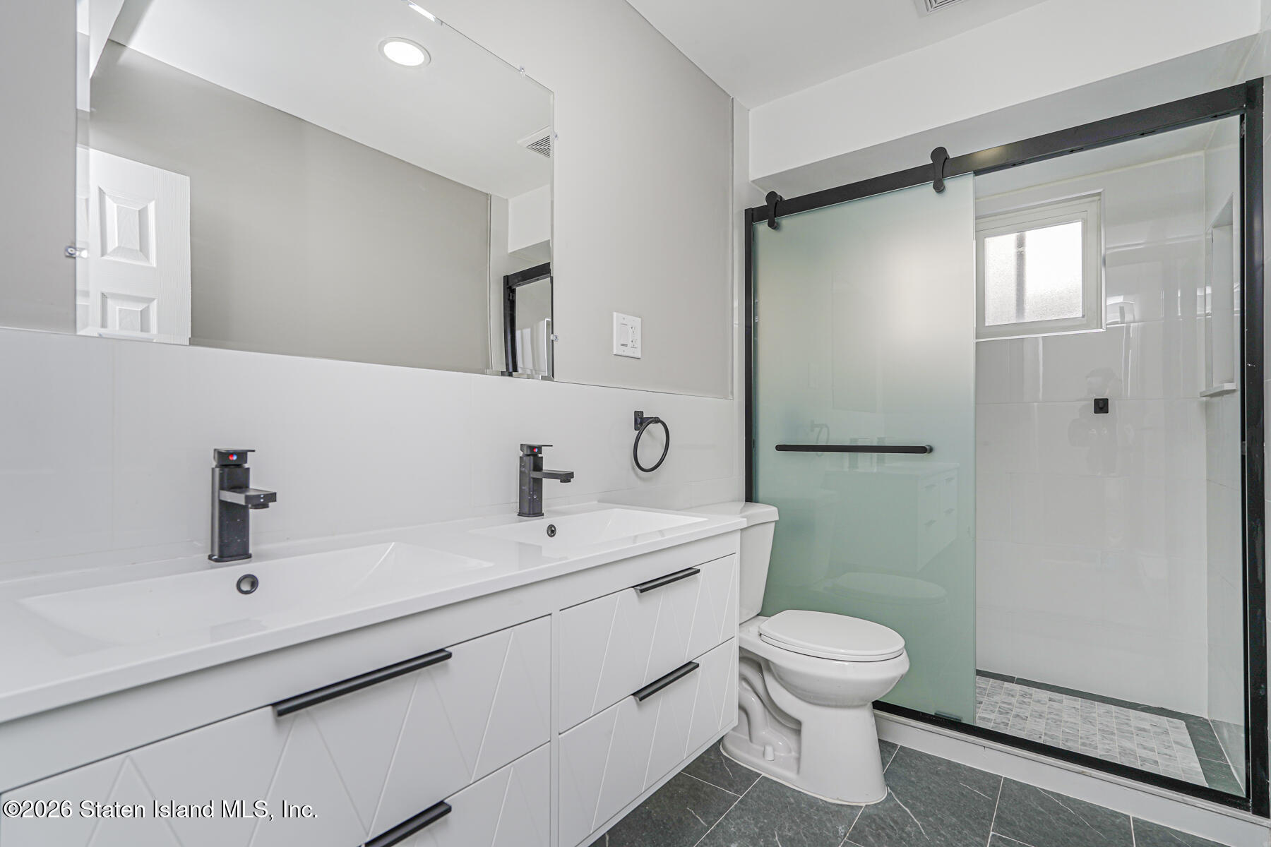39 Commerce Street Staten Island, NY 10314 - Photo 47 of 49 a bathroom with a sink and mirror with toilet