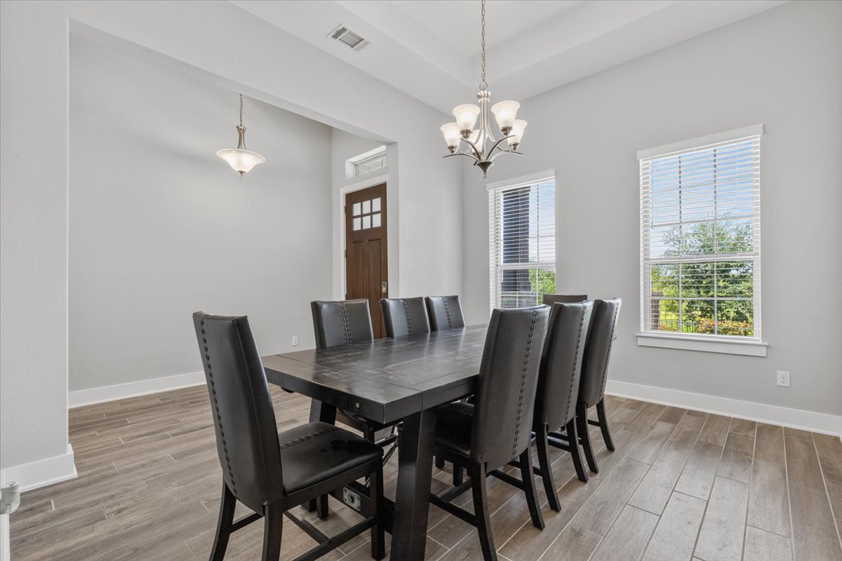320 Raptor Beak Way Cedar Creek, TX 78612 - Photo 8 of 40 This spacious dining area features sleek tile flooring, a sophisticated chandelier, and abundant natural light.
