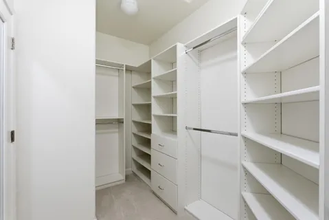 a view of walk in closet with empty racks