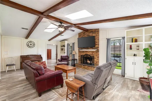 a living room with furniture a flat screen tv and a fireplace