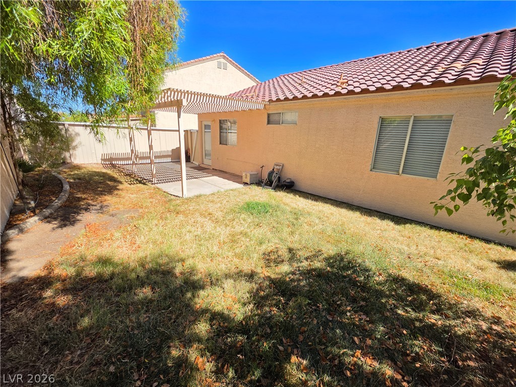 9609 Crystal Ridge Road Las Vegas, NV 89123 - Photo 20 of 21 A sunny back yard includes a concrete patio sheltered by a classic wooden pergola.