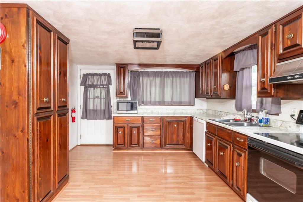 105 Dark Hollow Road Indiana, PA 15701 - Photo 17 of 44 a large kitchen with stainless steel appliances granite countertop a stove a sink dishwasher and a refrigerator with wooden cabinets
