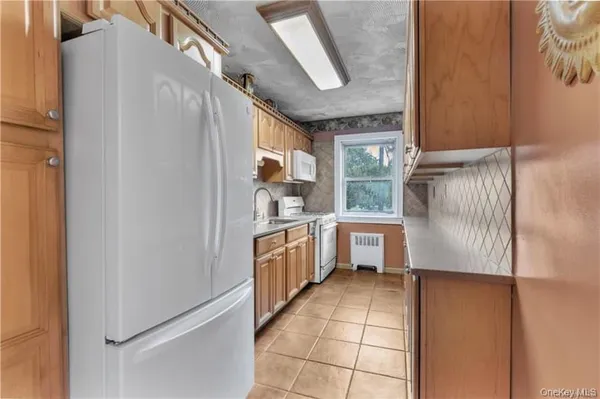 a kitchen with a refrigerator and white cabinets
