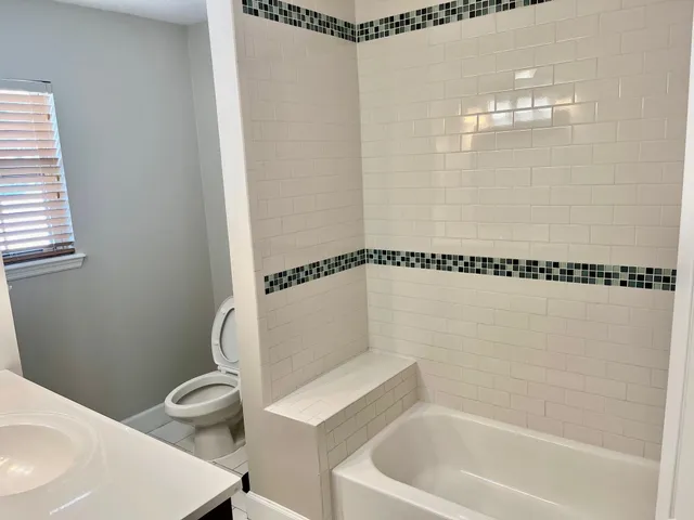 a bathroom with a white bath tub and a sink