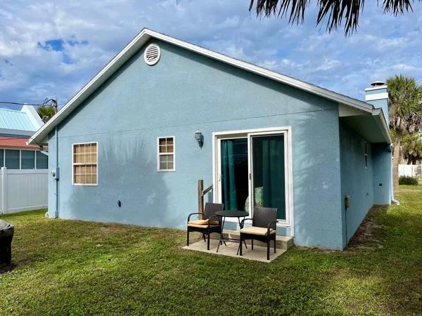 a backyard of a house with table and chairs