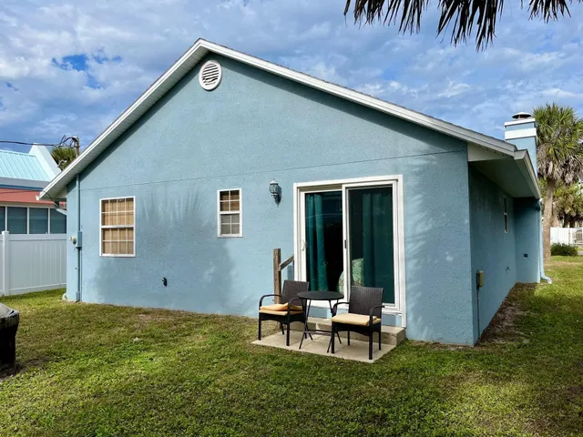 a backyard of a house with table and chairs