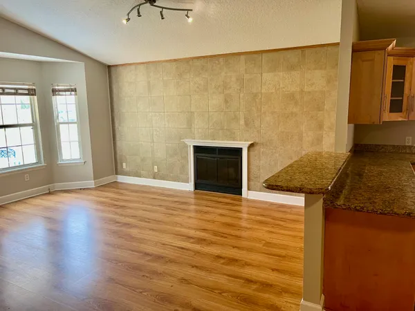 a view of empty room with wooden floor and fireplace