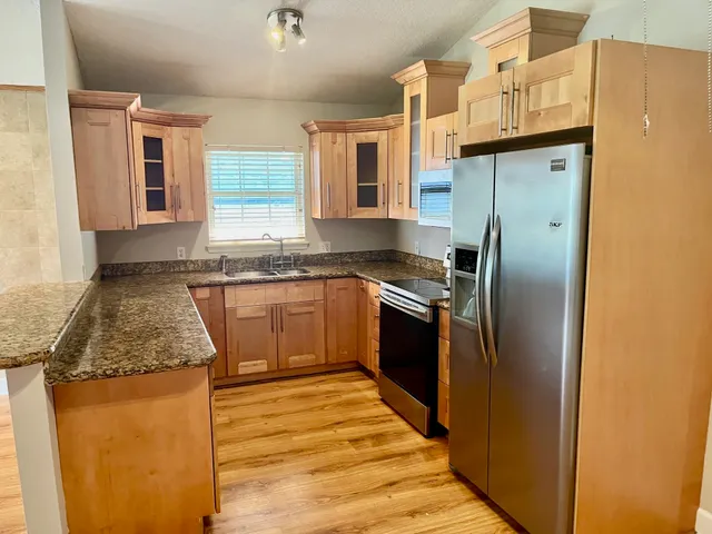 a kitchen with stainless steel appliances granite countertop a sink stove and refrigerator
