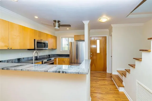 a large kitchen with stainless steel appliances granite countertop a sink a stove and a refrigerator