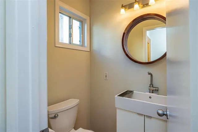 a bathroom with a sink mirror and toilet