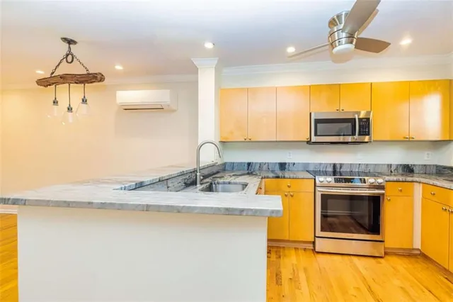 a kitchen with stainless steel appliances granite countertop a sink a stove and a microwave