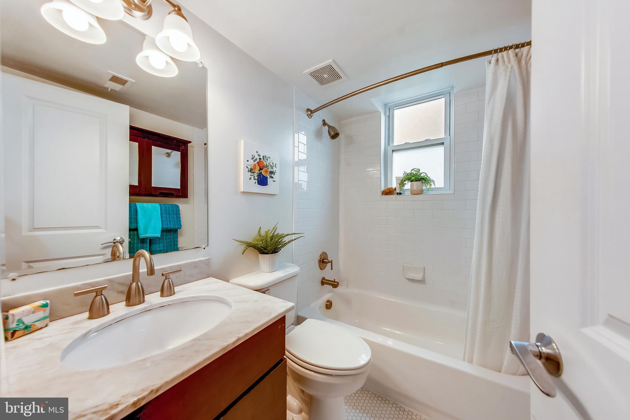420 16th Street Southeast, Unit 306 Washington, DC 20003 - Photo 17 of 32 a bathroom with a granite countertop sink a toilet a mirror and shower
