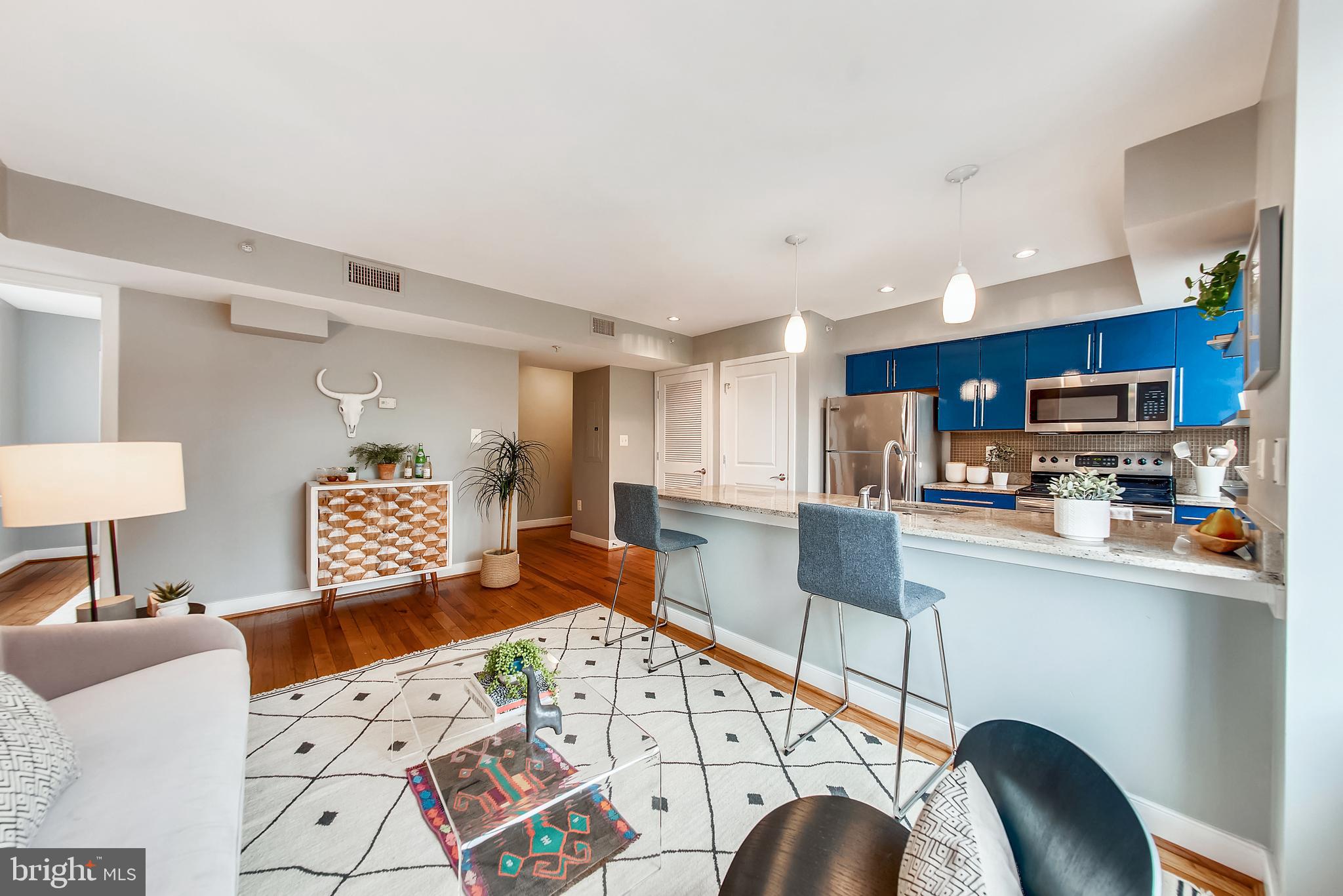 420 16th Street Southeast, Unit 306 Washington, DC 20003 - Photo 8 of 32 a kitchen with stainless steel appliances kitchen island granite countertop a refrigerator a stove a sink dishwasher and white cabinets with wooden floor
