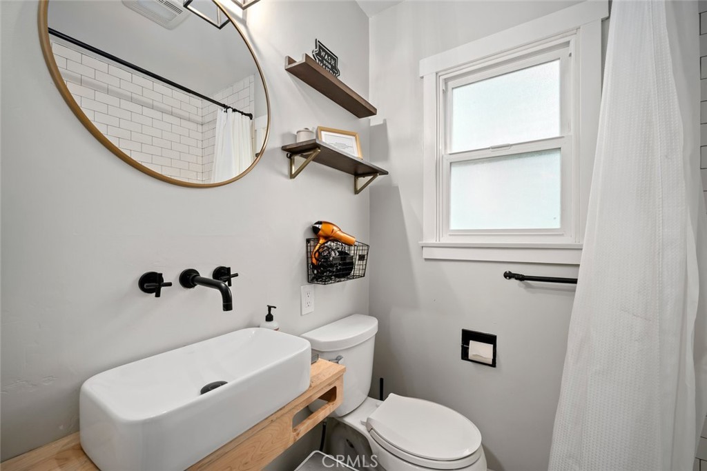 104 16th Street Paso Robles, CA 93446 - Photo 23 of 40 a white toilet sitting next to a bathroom sink and tub