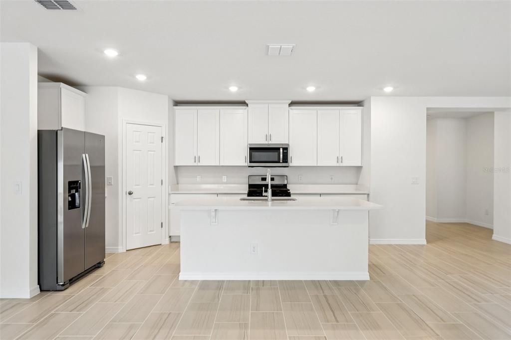 28009 Poppy Court Leesburg, FL 34748 - Photo 11 of 35 a kitchen with stainless steel appliances granite countertop a refrigerator a stove and a microwave
