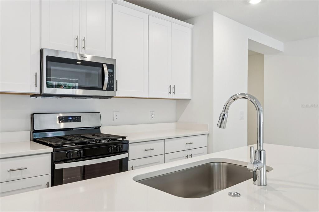 28009 Poppy Court Leesburg, FL 34748 - Photo 12 of 35 a kitchen with a sink and a microwave
