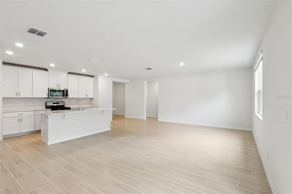28009 Poppy Court Leesburg, FL 34748 - Photo 13 of 35 a view of kitchen with kitchen island white cabinets and refrigerator