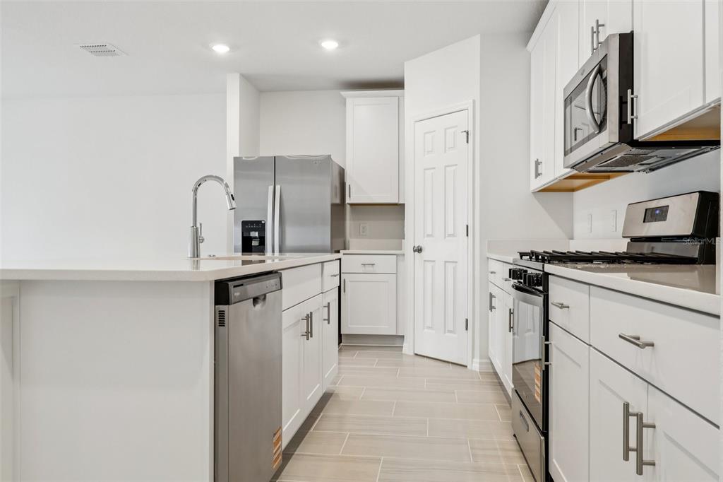 28009 Poppy Court Leesburg, FL 34748 - Photo 16 of 35 a kitchen with cabinets stainless steel appliances and a counter space