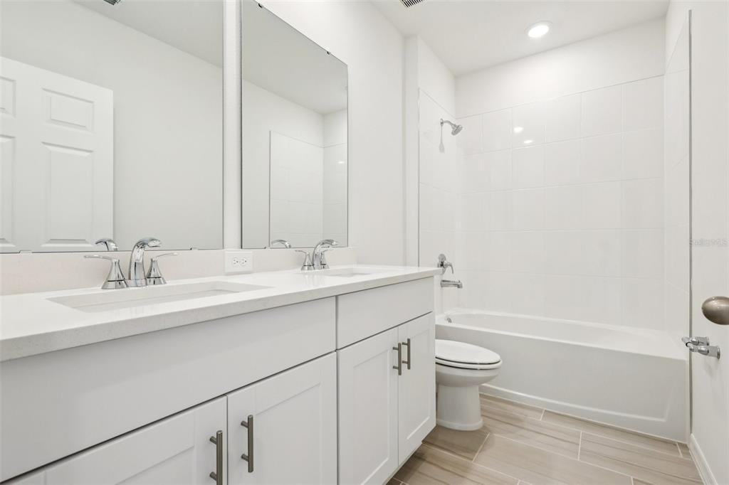 28009 Poppy Court Leesburg, FL 34748 - Photo 25 of 35 a bathroom with a sink a toilet and shower