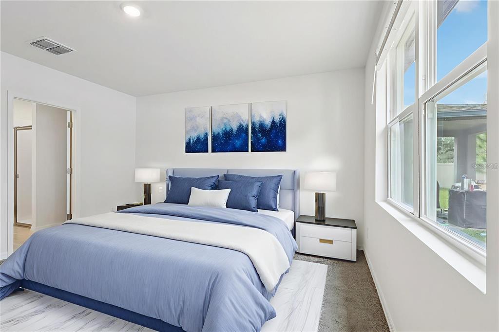 28009 Poppy Court Leesburg, FL 34748 - Photo 4 of 35 a bedroom with a large bed and a painting on the wall