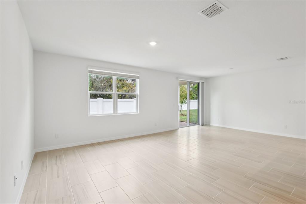 28009 Poppy Court Leesburg, FL 34748 - Photo 7 of 35 an empty room with wooden floor and windows