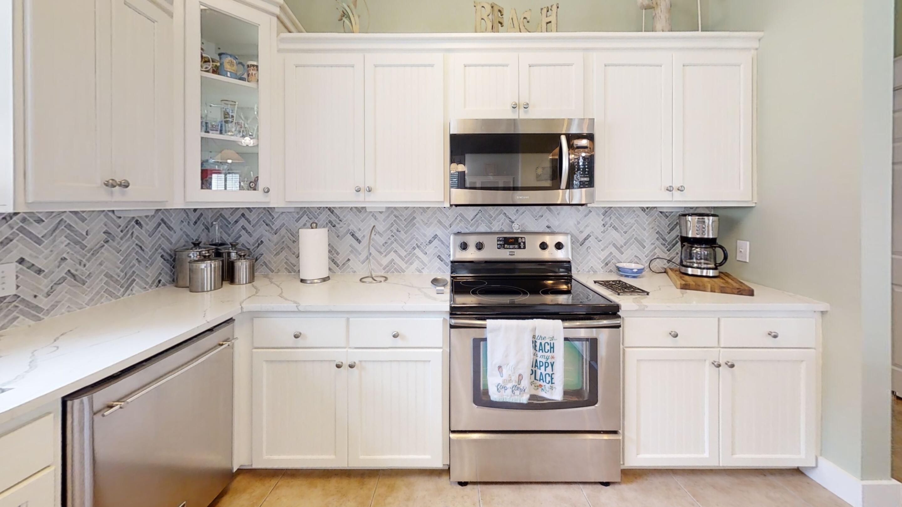 192 Birch Street Santa Rosa Beach, FL 32459 - Photo 20 of 51 a kitchen with stainless steel appliances a stove a microwave and cabinets