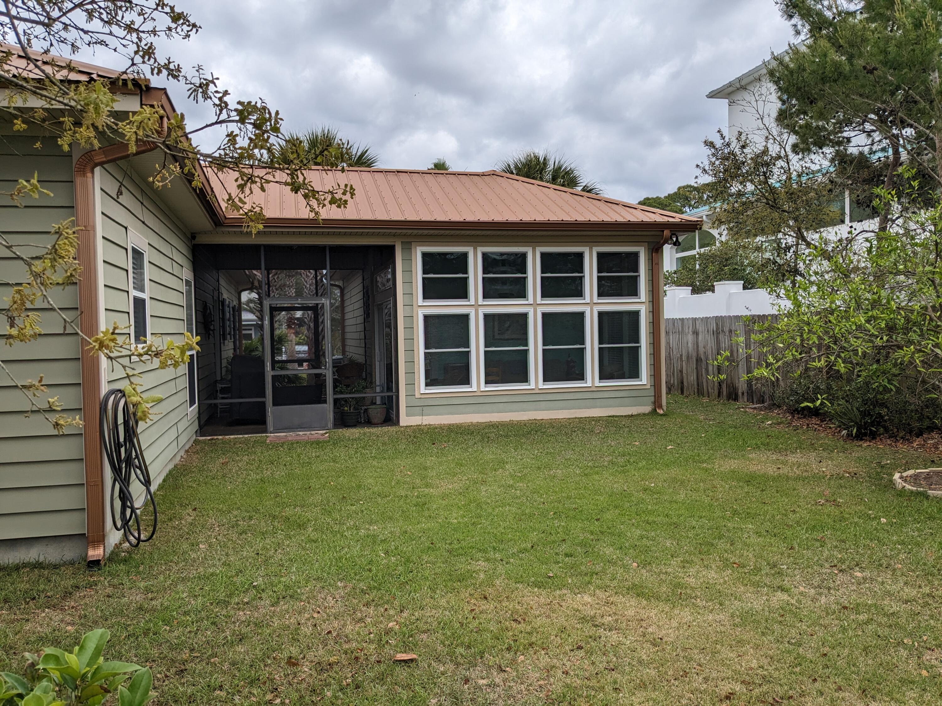 192 Birch Street Santa Rosa Beach, FL 32459 - Photo 46 of 51 a view of a wooden house with a large window and potted plants