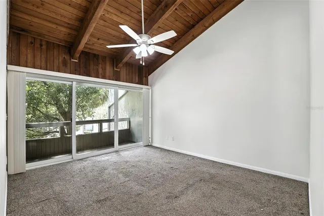 an empty room with a window and a ceiling fan