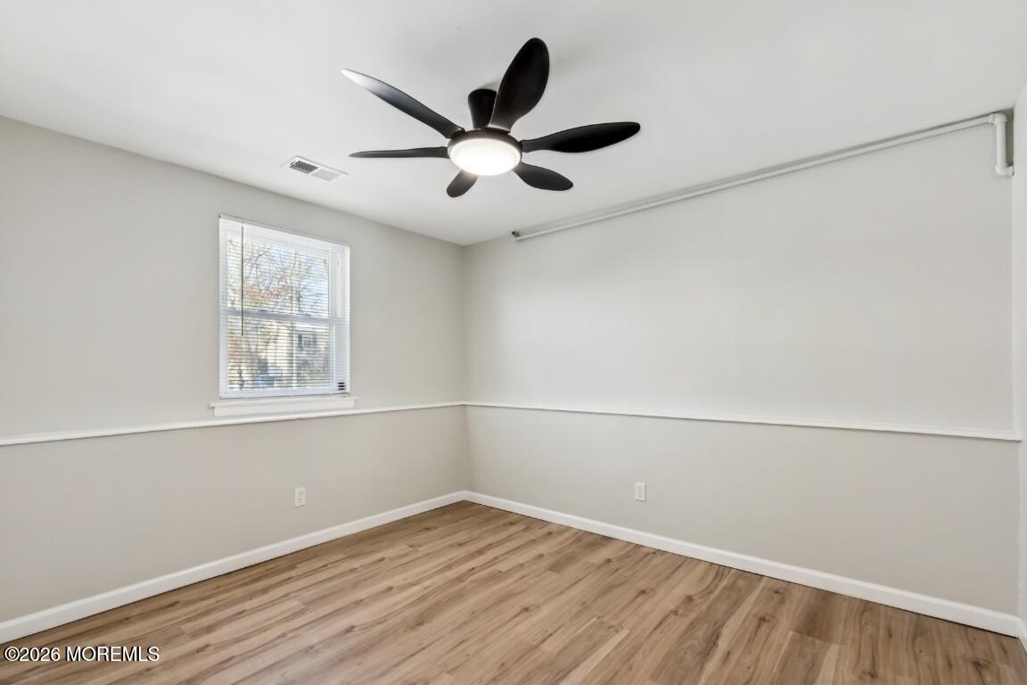 96 Twin Rivers Drive Toms River, NJ 08753 - Photo 28 of 37 a view of an empty room with wooden floor and a window