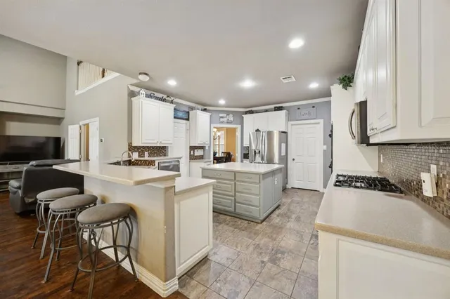 a view of a patio with couches and chairs with wooden floor and fence