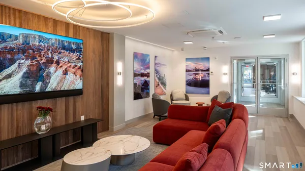 a living room with furniture and a painting on the wall