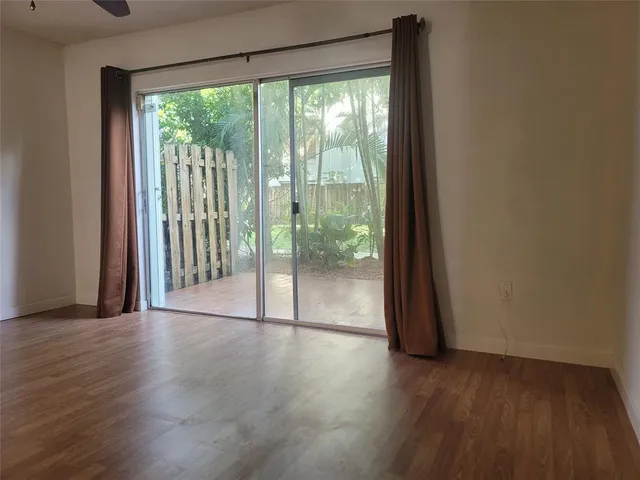 a view of a room with wooden floor and a floor to ceiling window
