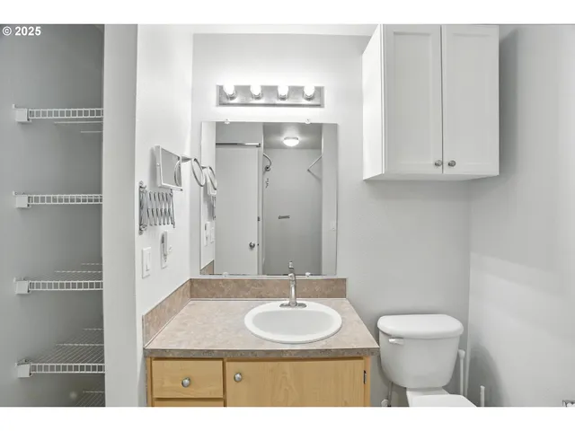 a bathroom with a granite countertop sink a toilet and a mirror