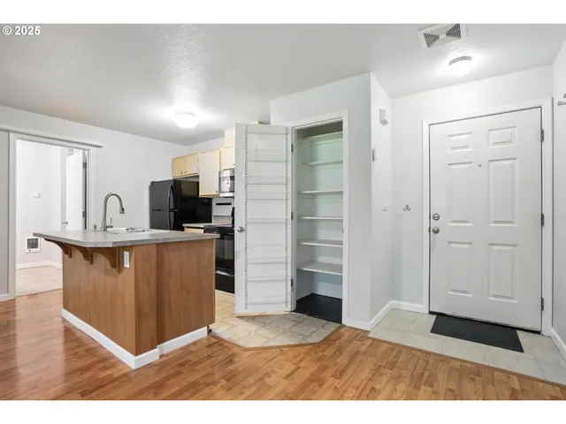 a view of kitchen with refrigerator cabinets and microwave