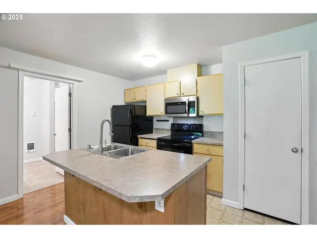 a kitchen with stainless steel appliances a microwave a sink and cabinets