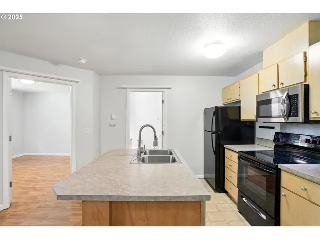a kitchen with sink a microwave and refrigerator