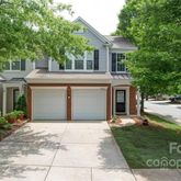 a front view of a house with a garden and a tree
