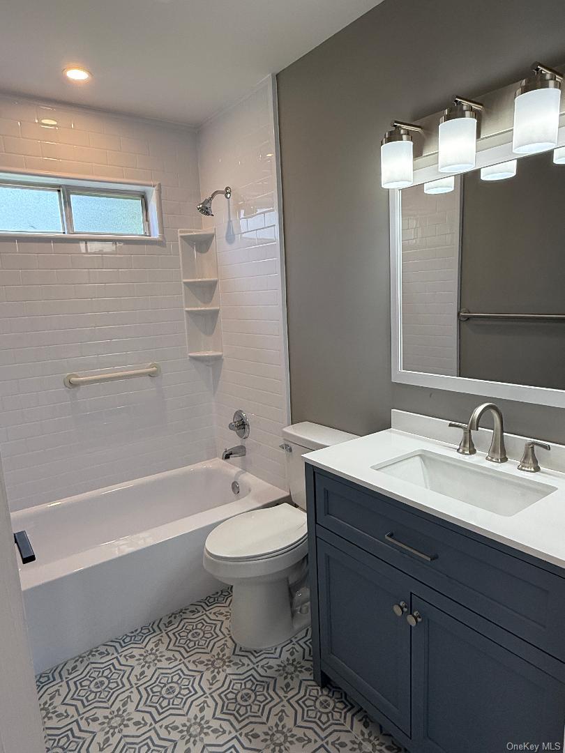 379 Larchmont Court Ridge, NY 11961 - Photo 11 of 17 a bathroom with a bathtub sink vanity mirror and toilet