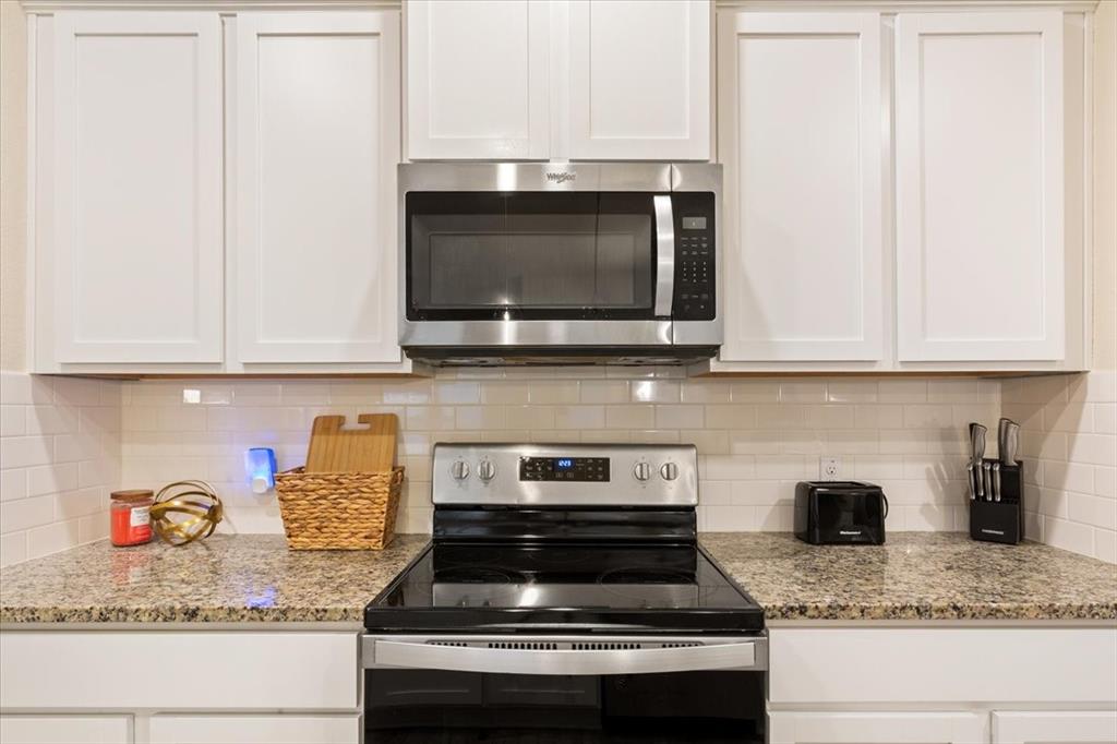 3105 Beutel Road Lorena, TX 76655 - Photo 11 of 26 a kitchen with granite countertop stainless steel appliances a stove microwave and cabinets