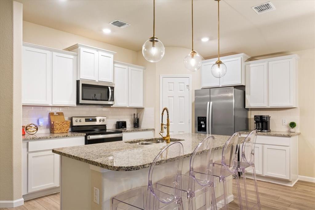3105 Beutel Road Lorena, TX 76655 - Photo 10 of 26 a kitchen with stainless steel appliances granite countertop a sink a stove a refrigerator cabinets and chairs