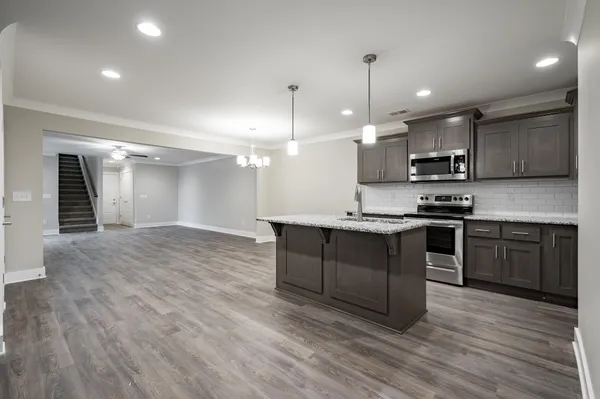 a kitchen with stainless steel appliances granite countertop a stove a sink and a refrigerator