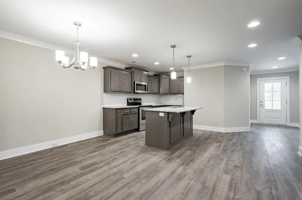 a large kitchen with stainless steel appliances kitchen island a large island in the center and wooden floors