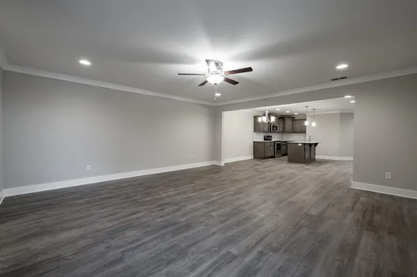 a view of a work space with chandelier fan and wooden floor